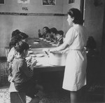 OSE relief worker Margot Stein serves soup to children at the Hotel Bompard internment camp.