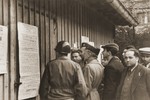 American officials read an election announcement posted outside the camp administration barracks in the Landsberg displaced persons camp.