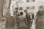 General Onslow Rolfe (top, right) and Major Irving Heymont (top, center) speak to Jewish DPs outside an administrative building in the Landsberg displaced persons camp.