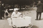 Evgenia Goldstein, the baby daughter of Sonja Schadur and Bernhard Goldstein, sits in her baby carriage in a Berlin park.