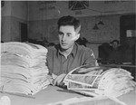 U.S. army photographer John O'Brien reviews a stack of Signal Corps photographs.