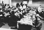 Jewish refugees from the Third Reich eat a meal in the dining hall of a refugee center in Luxembourg sponsored by the ESRA Jewish social welfare organization.