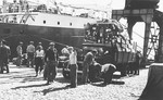 Portuguese dockworkers in the port of Lisbon prepare to transfer the luggage of Jewish refugees from a truck to the SS Mouzinho.