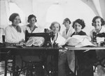 A group of young female employees pose at their sewing tables in the Palais de l'Habillement clothing company in Luxembourg.