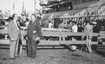 Albert Nussbaum (center right), Director of Transmigration for the American Joint Distribution Committee converses with a colleague on the pier in the port of Lisbon before the departure of the SS Mouzinho.