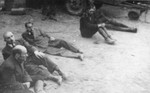 Five captured SS guards sit on the ground in the newly liberated Dora-Mittelbau concentration camp.