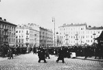 Jews are gathered in large numbers in a public square in the Warsaw ghetto.
