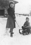 Renia Zylberszac pulls her sister, Mira on a sled in the Dabrowa ghetto.