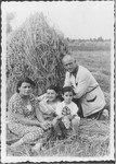 The Berkowicz family poses in front of a haystack on a farm [probably in Nadolnik, Poland].