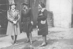 Three Jewish women who are posing as Poles, stand in a courtyard on the Aryan side of Warsaw.