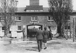 Red Cross worker Adeline Bustelman visits the former Dachau SS compound approximately one year after its liberation.
