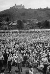 Spectators listen to a speaker during a Nazi rally in a valley below the Coburg fortress.