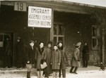 A group of Jewish DPs pose beneath a sign at the Emigrant Assembly Center.