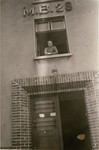 Masza Kuropatwa Sompolinski looks out the window of her living quarters, block 28, at the DP camp in Bergen-Belsen.