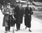 Three Polish Jews enjoy a stroll down a street in Krynica.