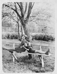 Alfred and Trudi Brosan sit back-to-back on a bench in the yard of their cottage in Hainbach, Austria.