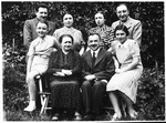 Group portrait of an extended Jewish family posing outside in a town in Bohemia.