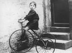 A young Belgian-Jewish boy rides a tricycle.

Pictured is Paul Halter.