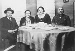 Prewar portrait of a Jewish family sitting at a table.