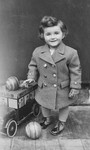 Studio portrait of a Jewish child with a toy car and balls in Zagreb, Croatia.