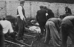 The bodies of sixty Limanowa Jews who were executed in the Jewish cemetery, are prepared for burial.