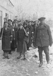 Escorted by a Pole, a group of Jewish men and youth from Olkusz march to a work site carrying shovels.