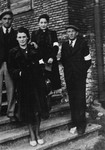 Four young Jewish men and women pose wearing armbands on a staircase in the Olkusz ghetto.