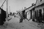 A German soldier patrols a street in the Konskowola ghetto with his dog.