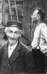 Two Jewish men stand outside a wooden building in Konskowola.