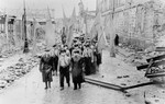 Jewish survivors carrying flags march along Bielanska Street [probably during a demonstration marking the fourth anniversary of the Warsaw ghetto uprising].
