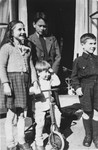 Alfred Münzer, a Jewish child who is living in hiding, poses with his foster brother and two neighbors.