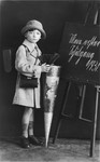 Portrait of a Jewish child holding a candy cone on his first day of school.