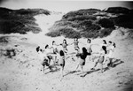 Children who had been in hiding during the war dance a hora on a beach.