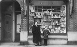 Gitel and Alfred Münzer pose in front of their cosmetics store in The Hague.