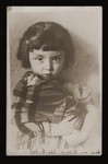 Portrait of a young Jewish girl holding a porcelain doll.