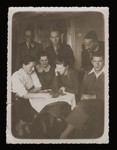 Members of the Feder family gather around a chess game.