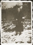 Mirla Lustiger walks on a snowy street in the Bedzin ghetto wearing an armband.