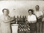 The Cawadel family fills bottles of soda in their factory.