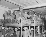Survivors wave to American liberators from their bunks in the infirmary barracks for Jewish prisoners in the Ebensee concentration camp.