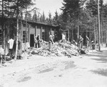 Survivors rummage through piles of clothing outside a barracks in the newly liberated Ebensee concentration camp.