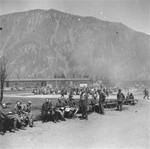 Survivors sit on benches along the perimeter of the former roll call area in the Ebensee concentration camp.