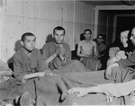 Survivors sit on the floor in the infirmary barracks for Jewish prisoners in the Ebensee concentration camp.