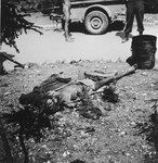 A corpse lies on the ground in the Ebensee sub-camp of Mauthausen after liberation.