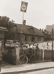 Young Nazi party supporters stand next to an election poster that reads: "Adolf Hitler will provide work and bread!  Elect List 2!'  Posted on the wall at the right are posters urging women and workers to support the Nazis.