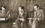 Minister of Propaganda Joseph Goebbels waits while Adolf Hitler reviews a document in the chancellery.