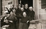 Women in a small village wave and salute Hitler's passing Motorcade.