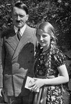 Adolf Hitler poses with a young girl, to whom he has given his autograph.