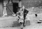 Three Jewish children pose outside on their family farm prior to their emigration from Germany.