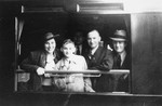 A Jewish family poses at the window of their railcar before the train leaves the station.