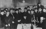 A group of men gather around Ernst Eizikowits to celebrate his wedding to Helena Friedmann.